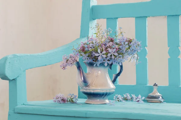 Stillleben mit Frühlingsblumen auf blauer Bank — Stockfoto