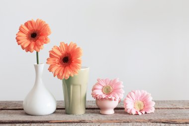 Eski ahşap masa üzerinde vazoda gerbera