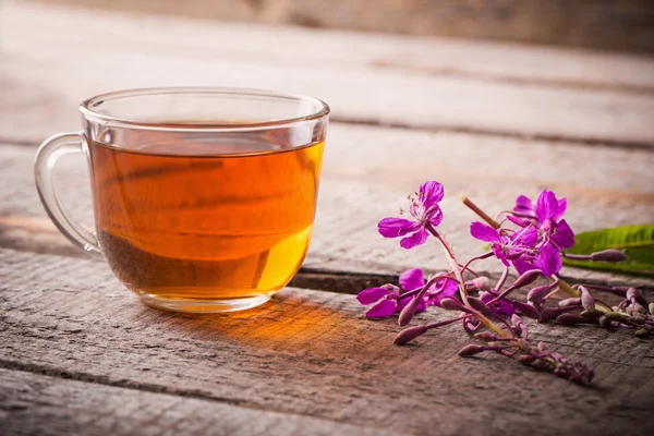 Cup of tea with willow-herb on wooden background — Stock Photo, Image