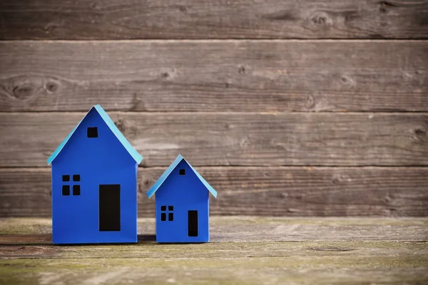 Una casa di carta si erge su uno sfondo di legno — Foto Stock