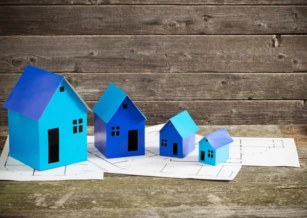 Casas de papel azul sobre fondo de madera —  Fotos de Stock