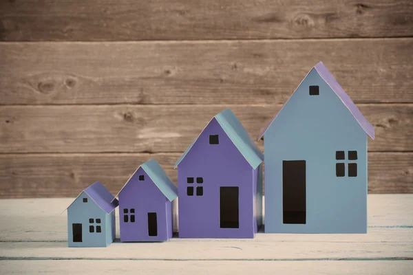 Une maison en papier se dresse sur un fond en bois — Photo