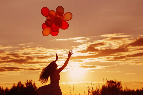 Gün batımında Balonlu genç kadın — Stok fotoğraf