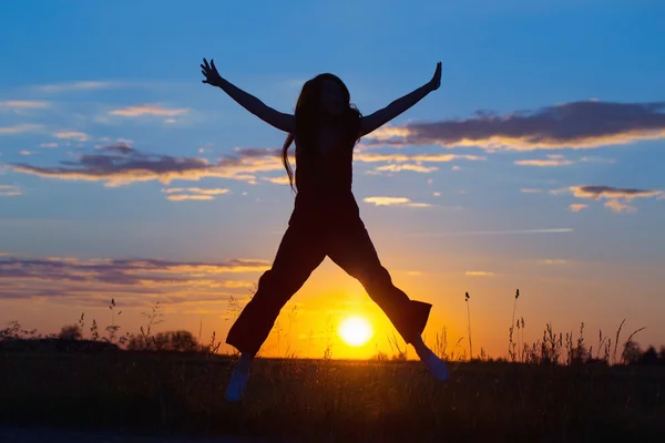 Les jeunes femmes sautent joyeusement au coucher du soleil — Photo