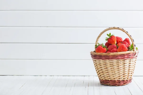 Frische Erdbeeren im Korb auf weißem Holzhintergrund — Stockfoto