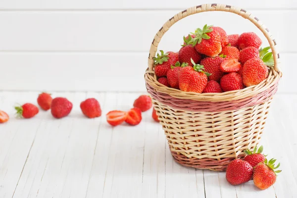 Frische Erdbeeren im Korb auf weißem Holzhintergrund — Stockfoto