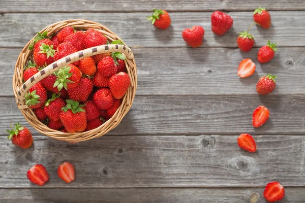 Erdbeeren im Korb auf Holzgrund — Stockfoto