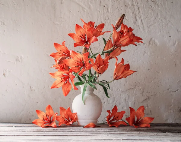 Лилия в вазе на деревянном столе — стоковое фото