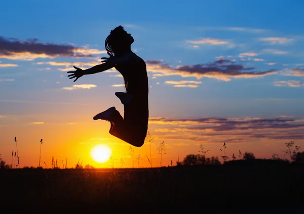 Les jeunes femmes sautent joyeusement au coucher du soleil — Photo