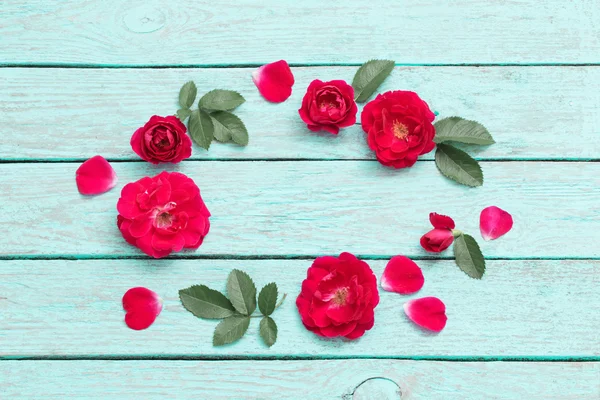 Rosas rojas sobre fondo azul de madera — Foto de Stock