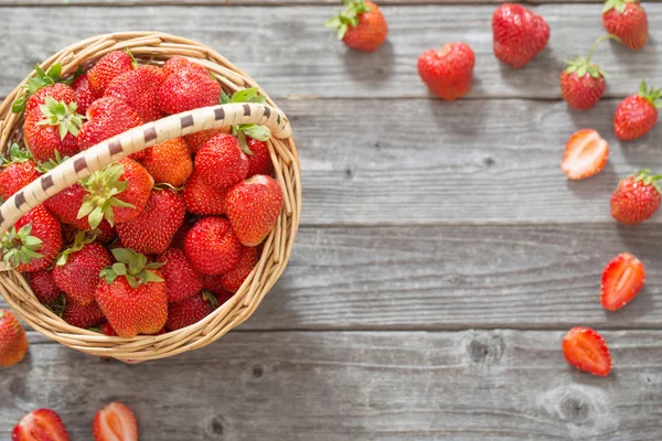 Erdbeeren im Korb auf Holzgrund — Stockfoto