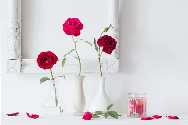 Roses rouges dans un vase sur fond blanc mur — Photo