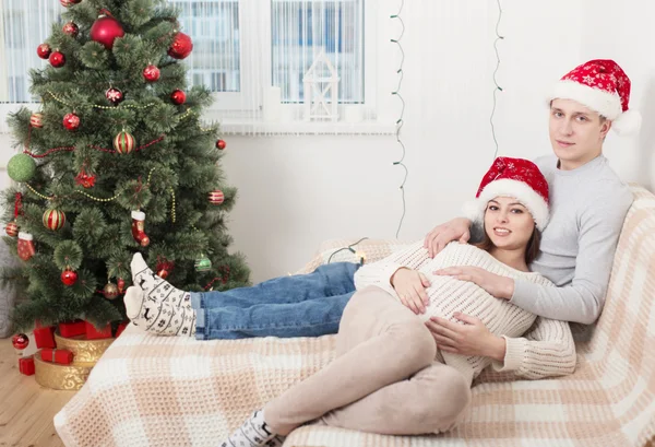 Glückliches Paar mit Weihnachtsbaum drinnen — Stockfoto
