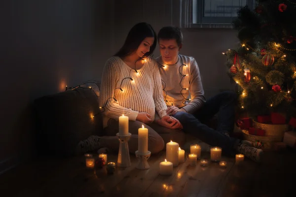 Glückliches Paar mit Weihnachtsbaum drinnen — Stockfoto