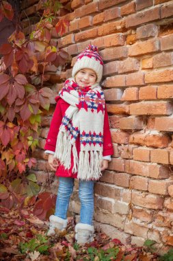 Sonbaharda arka plandaki güzel küçük kız yaşlı tuğla duvar