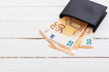 Beyaz ahşap arka planda siyah cüzdan euro.