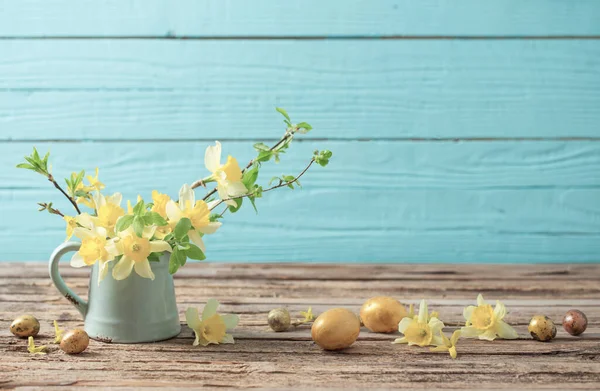 木制背景上的金色复活节彩蛋和黄色花朵 — 图库照片