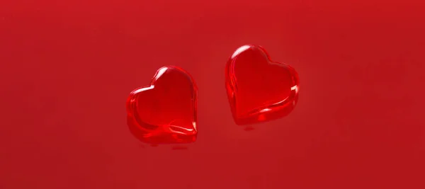 Kırmızı Arka Planda Kırmızı Cam Kalpler — Stok fotoğraf