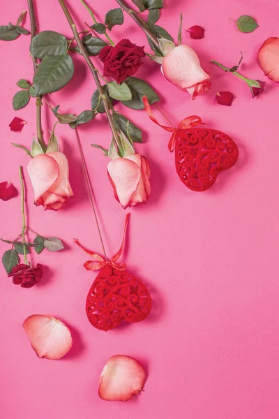ピンクの紙の背景に赤いハートとバラ — ストック写真