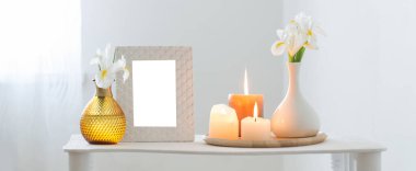 beyaz çerçeve, yanan mumlar ve beyaz arkaplanda çiçekler