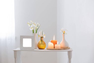 beyaz çerçeve, yanan mumlar ve beyaz arkaplanda çiçekler