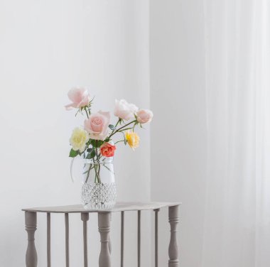 Beyaz arka planda cam sürahi içinde güzel güller