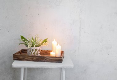 Vazodaki vadi zambağı. Arka planda yanan mumlar. Eski beyaz duvar.