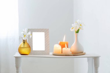 beyaz çerçeve, yanan mumlar ve beyaz arkaplanda çiçekler