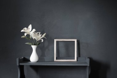 Vazodaki çiçekler ve arka plandaki ahşap çerçeve.