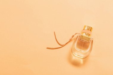 Turuncu arka planda parfüm şişesi