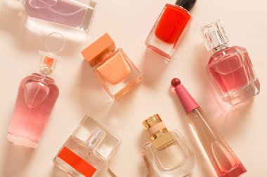 Turuncu arka planda bir grup parfüm şişesi