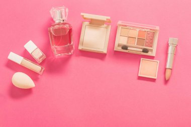 Pembe arka planda parfümlü dekoratif kozmetik.