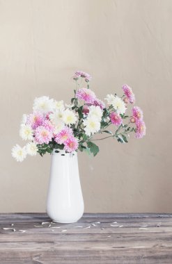 Vazodaki kasımpatılar eski ahşap masada.