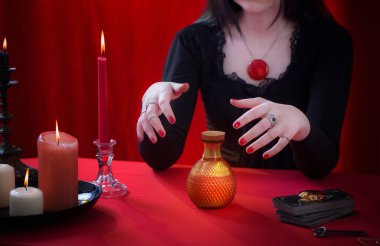 Kırmızı arka planda sihirli iksir ile genç cadı ve şişe