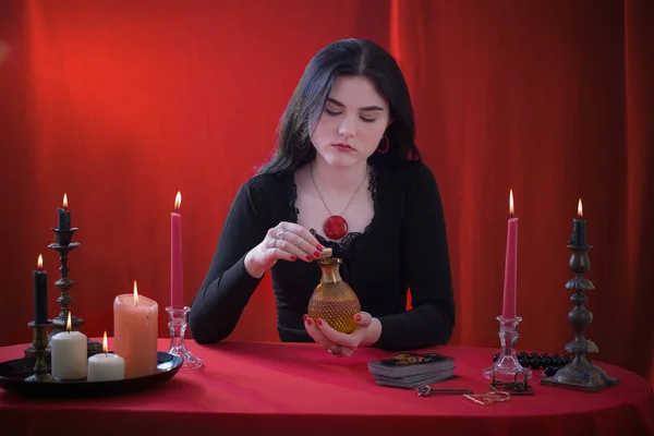 Joven Bruja Sosteniendo Frasco Con Poción Mágica Sobre Fondo Rojo — Foto de Stock