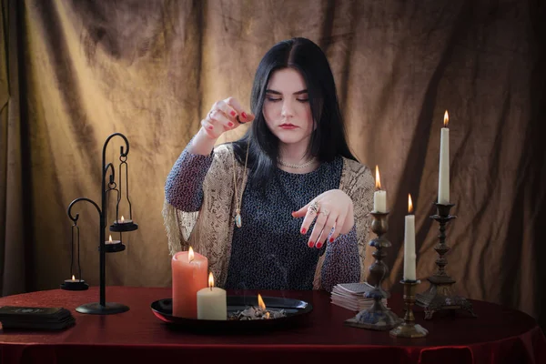 年轻的女巫在黑暗的背景下与燃烧的蜡烛共舞 — 图库照片