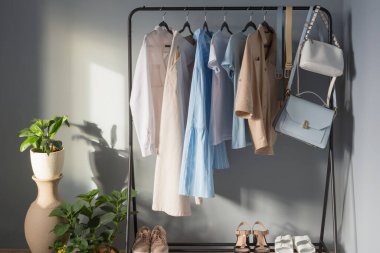 Açık renkli kadınlar yaz kıyafetleri ve askıda ayakkabılar.