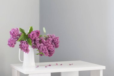 güzel leylak çiçekleri beyaz sürahi içinde ahşap masada