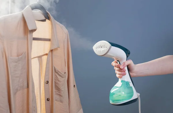 Mão Feminina Com Vapor Camisa Fundo Azul — Fotografia de Stock