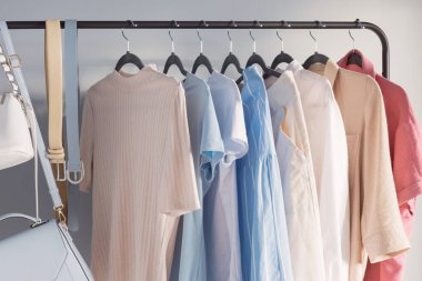 Açık renkli kadınların yaz kıyafetleri askıda.