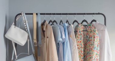 Açık renkli kadınların yaz kıyafetleri askıda.