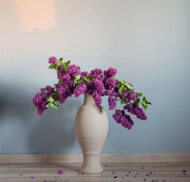 Ahşap zeminde vazoda leylak çiçekleri