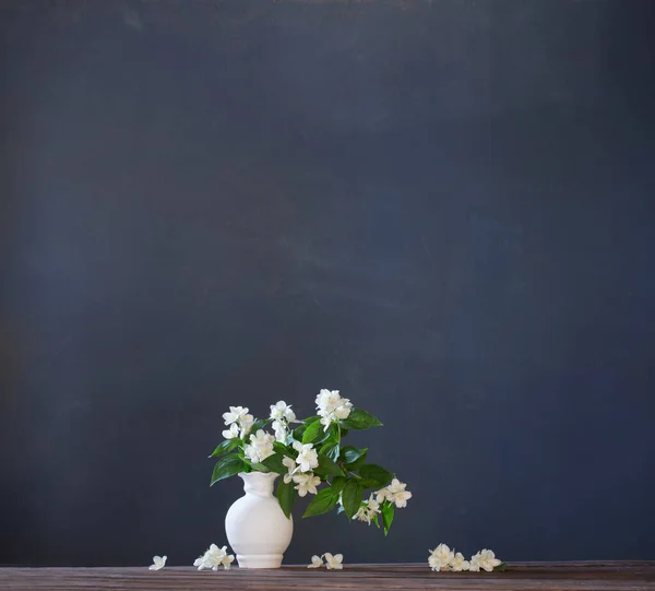 jasmine flowers in ceramic vase on white background