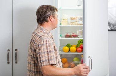 Dolapta yemek getiren olgun erkekler.