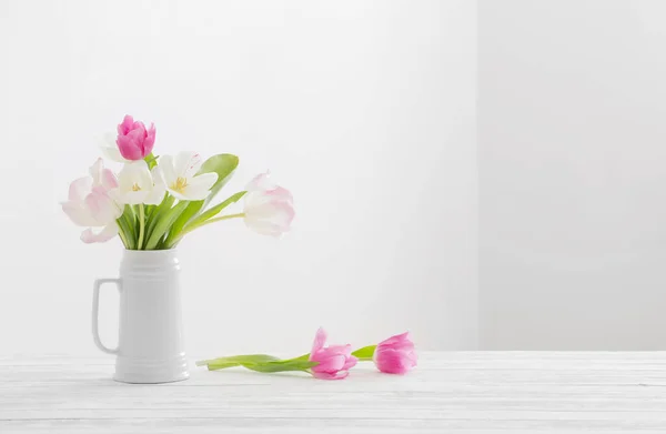 白色背景的水壶中的白色和粉色郁金香 — 图库照片