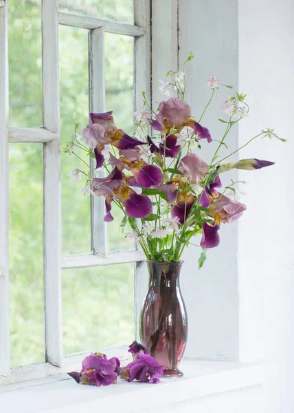 白い古い窓ガラスの花瓶に虹彩の花 — ストック写真