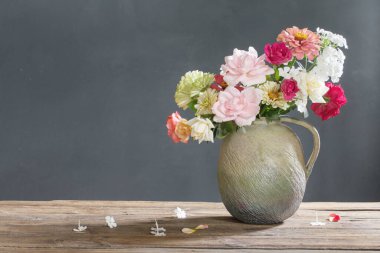 Tahta masadaki seramik sürahide yaz çiçekleri