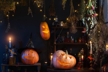 Cadılar bayramı balkabakları ışıklarla, yanan mumlarla ve cadıların evinde sihirli iksirlerle