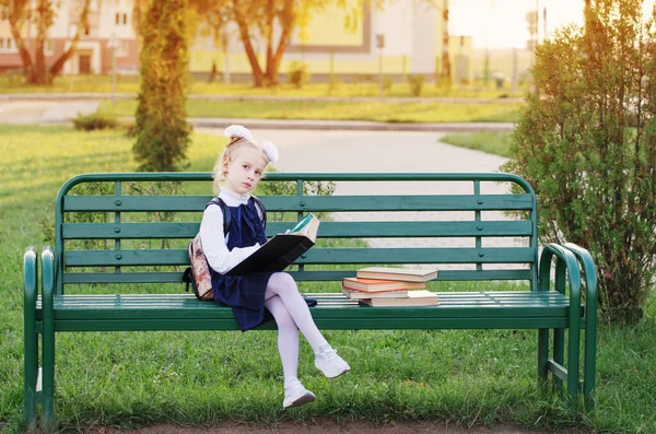 小女孩坐在长椅上看书 — 图库照片