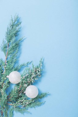 ardıç dalları ve mavi arkaplanda beyaz toplar